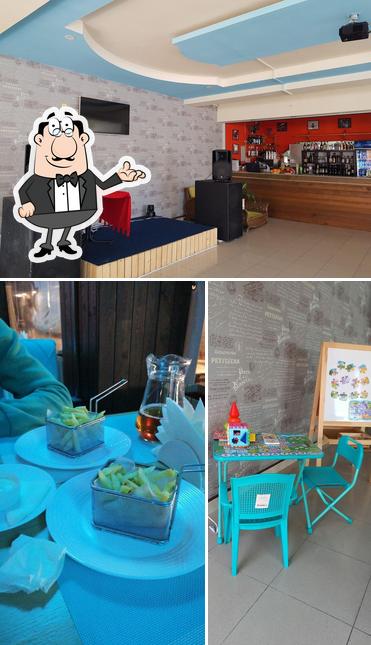 Снимок, на котором видны внутреннее оформление и столики в Веранда